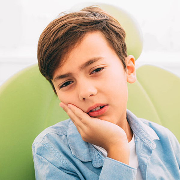 Boy with tooth ache holding his cheek