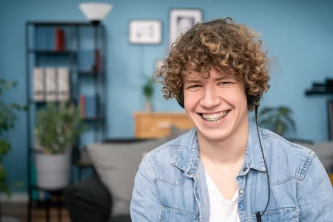 Teen boy with braces smiling while listening to music